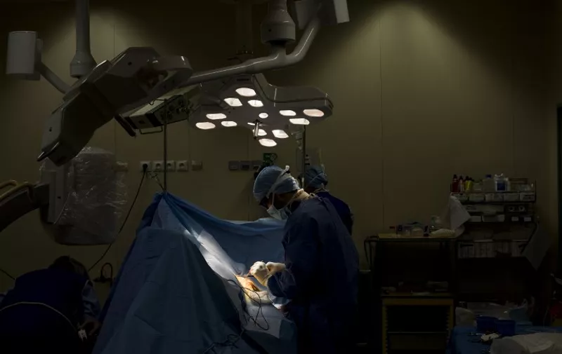 A surgeon implants a pacemaker to a patient in an operating room, on July 19, 2013 at the Argenteuil hospital, in a Paris suburb. AFP PHOTO / FRED DUFOUR / AFP PHOTO / FRED DUFOUR