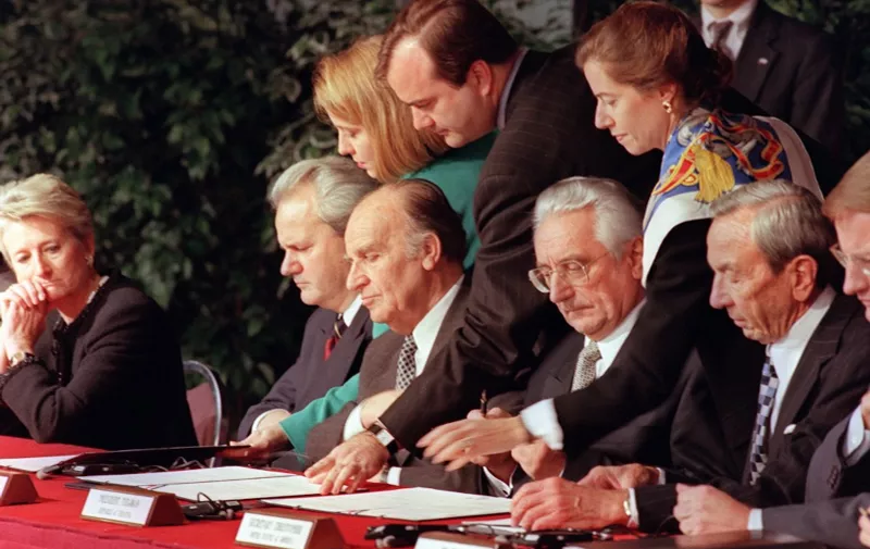 Serbian president Slobodan Milosevic (2dL), Bosnian President Alija Izetbegovic (3dL), Croatian President Franjo Tudjman (4th L) and US Secretary of State Warren Christopher (R), initialize a peace accord 21 November 1995 between their countries at the conclusion of the Proximity Peace Talks at Wright Patterson Air Force Base near Dayton, Ohio. (Photo by PAUL J. RICHARDS / AFP)