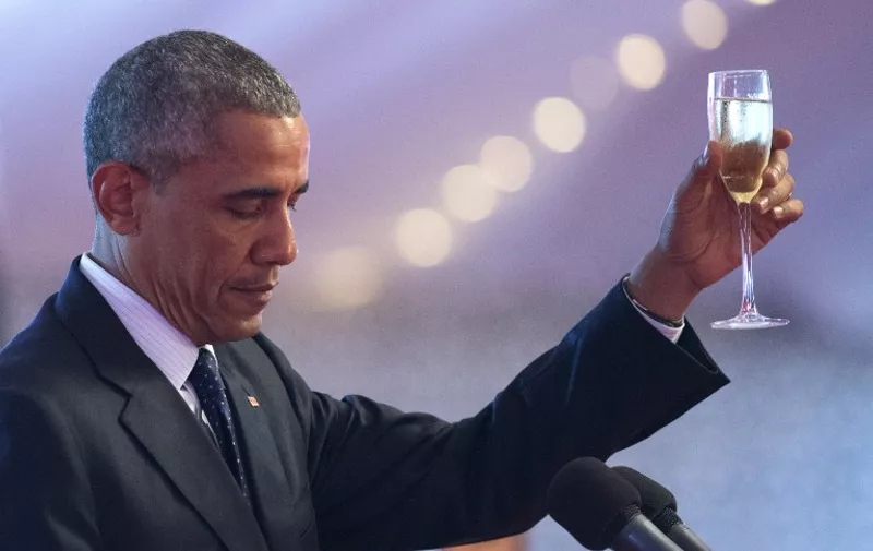 US President Barack Obama raises a toast during a State Dinner hosted by Kenyan President at the State House in Nairobi, on July 25, 2015.  Obama arrived in Kenya on Friday, his first visit as president to his father's birthplace and the first to the East African nation by a serving US leader. AFP PHOTO / SAUL LOEB