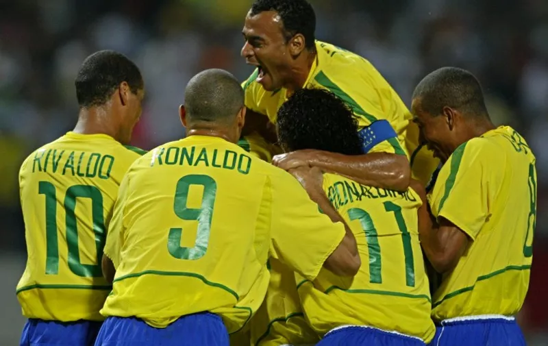 Brazilian captain Cafu jumps over teamates to celebrate Rivaldo's goal 08 June 2002 at the Jeju World Cup Stadium in Seogwipo, before the first round Group C action between Brazil and China in the 2002 FIFA World Cup Korea/Japan. Brazil defeated China 4-0.  AFP PHOTO/GREG WOOD / AFP / GREG WOOD