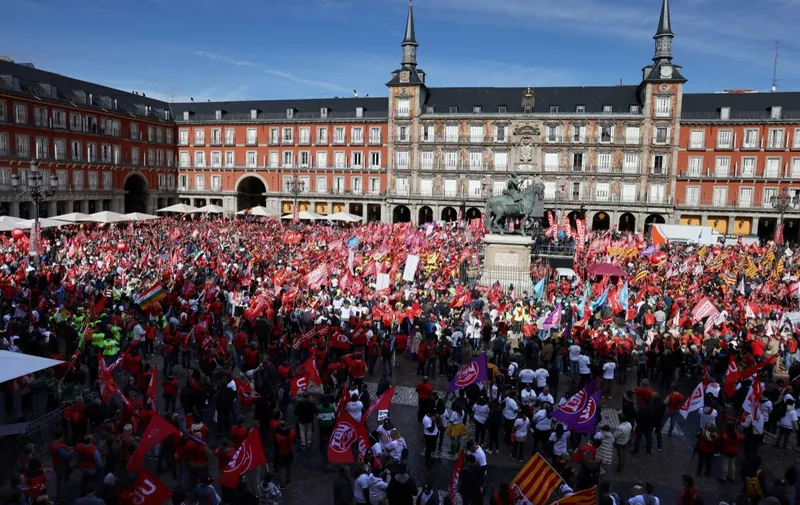 Protestors wave trade union flags during a demonstration called by the CCOO and UGT trade unions, demanding decent wage increases to maintain purchasing power, on the Plaza Mayor square in Madrid on November 3, 2022. (Photo by Thomas COEX / AFP)