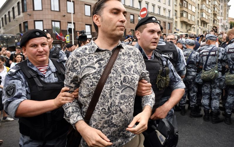 Russian police officers detain French journalist, Emmanuel Grynszpan,   during a march to protest against the alleged impunity of law enforcement agencies in central Moscow on June 12, 2019. - More than 50 people including opposition leader Alexei Navalny were detained as police sought to break up a peaceful Moscow rally against the alleged impunity of law enforcement agencies. The unsanctioned rally was initially called to press for the freedom of investigative journalist Ivan Golunov who was last week arrested on trumped-up drugs charges but released on the eve of the march. (Photo by Alexander NEMENOV / AFP) / The erroneous mention[s] appearing in the metadata of this photo by Alexander NEMENOV has been modified in AFP systems in the following manner: [French journalist Emmanuel Grynszpan] instead of [a protester]. Please immediately remove the erroneous mention[s] from all your online services and delete it (them) from your servers. If you have been authorized by AFP to distribute it (them) to third parties, please ensure that the same actions are carried out by them. Failure to promptly comply with these instructions will entail liability on your part for any continued or post notification usage. Therefore we thank you very much for all your attention and prompt action. We are sorry for the inconvenience this notification may cause and remain at your disposal for any further information you may require.