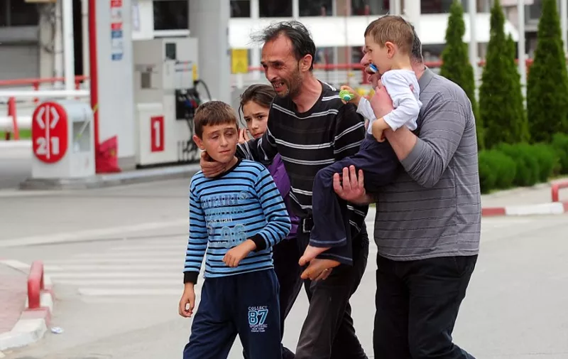 A man and his family leave the conflict area near in Kumanovo on May 9, 2015 after clashes in which four policemen were injured. The clashes took place during a dawn police raid in a part of the town populated mainly by ethnic Albanians in what a spokesman described as an operation against an "armed group", heightening fears of instability in the ex-Yugoslav republic after months of political crisis. AFP  PHOTO / ROBERT ATANASOVSKI
