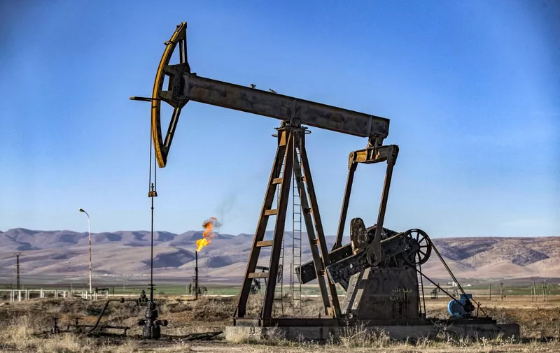 This picture taken on December 18, 2022 shows a view of an oil derrick pump in the countryside near the town of al-Qahtaniyah in Syria's northeastern Hasakah province, close to the border with Turkey. (Photo by Delil SOULEIMAN / AFP)