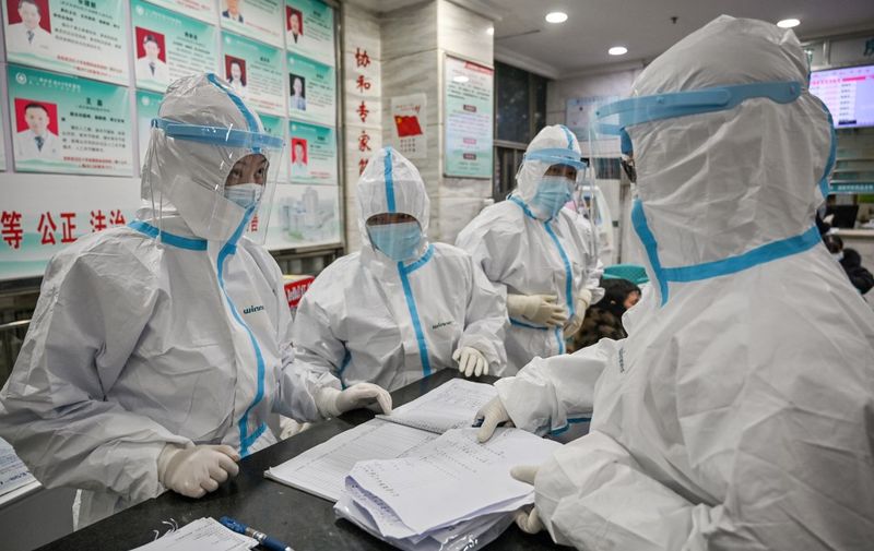(FILES) This file photo taken on January 25, 2020 shows medical staff members wearing protective clothing to help stop the spread of a deadly virus which began in the city as they work at the Wuhan Red Cross Hospital in Wuhan. - For eight days, starting on January 23, 2020, an AFP team lived and worked at the centre of a global health emergency, witnessing how life in the Chinese city of Wuhan was turned upside down as it was cut off from the world. (Photo by Hector RETAMAL / AFP) / TO GO WITH China-health-virus-Wuhan,FOCUS by Sebastien Ricci