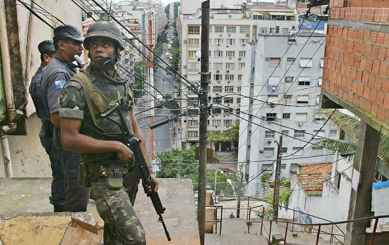 Soldiers of the Army's Special Unit search in the Pavao and Pavazinho favela in Copacabana, Rio de Janiero, Brazil, 28 July 2004, for drug traffickers who might have bought arms stolen to the Army.   AFP PHOTO/VANDERLEI ALMEIDA (Photo by VANDERLEI ALMEIDA / AFP)