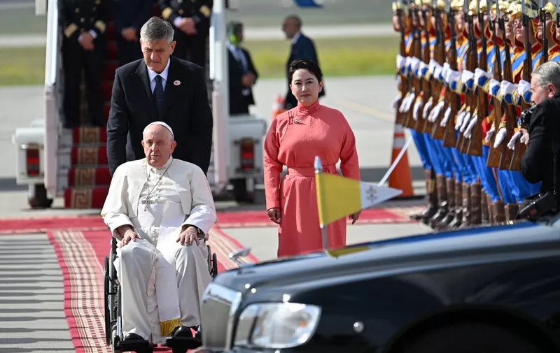 Pope Francis is received by Mongolia's Minister of Foreign Affairs Batmunkh Battsetseg (R, in red) during his arrival at Chinggis Khaan International Airport in Ulaanbaatar on September 1, 2023. (Photo by Alberto PIZZOLI / AFP)