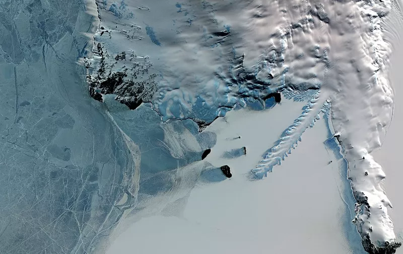 An image from the Terra satellite shows the Erebus ice tongue (R) protruding 12kms off the coast of Ross Island into the frozen waters of McMurdo sound in Antartica.  The blue-rimmed, serrated "knife" is formed by the rapidly moving valley glacier on the side of Mt Erebus volcano extending into the Southern Ocean during summer when waves carve elaborate structures in the ice. In winter the sea freezes once more around these new shapes.  AFP PHOTO/NASA/EARTH OBSERVATORY (Photo by EARTH OBSERVATORY / NASA / AFP)