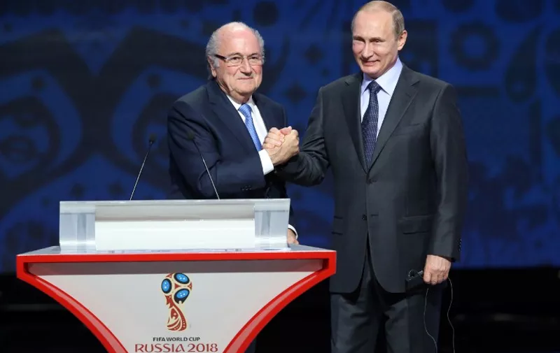 Outgoing FIFA president Sepp Blatter (L) shakes hands with Russian President Vladimir Putin ahead of the preliminary draw for the 2018 World Cup qualifiers at the Konstantin Palace in Saint Petersburg on July 25, 2015.  AFP PHOTO / KIRILL KUDRYAVTSEV