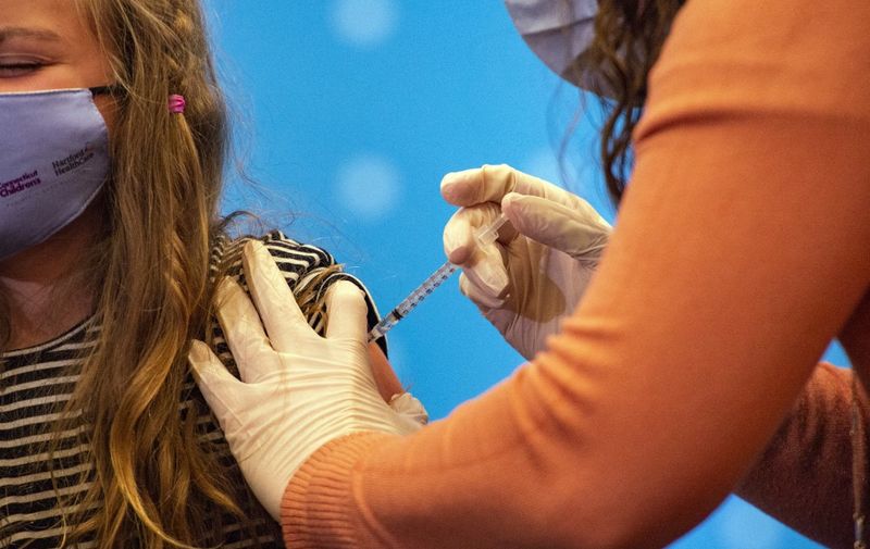 A eight year old child receives the Pfizer-BioNTech Covid-19 Vaccine for 5-11 year old kids at Hartford Hospital in Hartford, Connecticut on November 2, 2021. - An expert panel unanimously recommended Pfizer-BioNTech's Covid vaccine for five- to 11-year-olds on November 2, the penultimate step in the process that will allow injections in young children to begin this week in the United States. The Centers for Disease Control and Prevention (CDC), the top US public health agency, was expected to endorse that recommendation later in the day. (Photo by JOSEPH PREZIOSO / AFP)