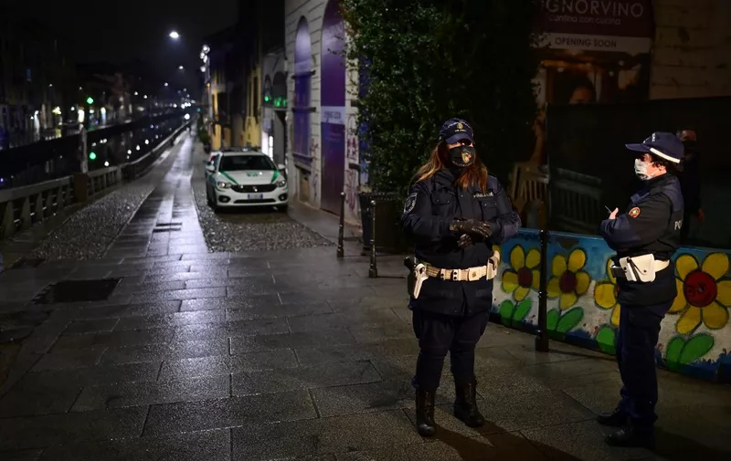 Police officers make a round in the Navigli district in southern Milan on October 22, 2020, during the closing of the bars and restaurants. - Lombardy region imposes a nighttime virus curfew from 11:00 pm until 5:00 am. (Photo by Miguel MEDINA / AFP)