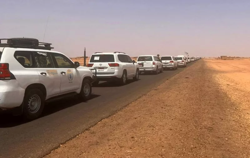 A convoy leaving Khartoum advances on a road towards Port Sudan, on April 23, 2023, as people flee the battle-torn Sudanese capital. (Photo by Abubakarr JALLOH / AFP)
