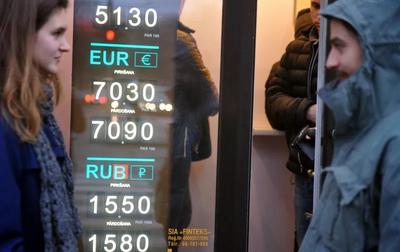 TO GO WITH AFP STORY BY MIKE COLLIER -  People walk past a currency exchange office in Riga, Latvia on December 27, 2013. Latvia has blazed a unique path in meeting tough rules for its January 1, 2014 eurozone entry, doing so while paying off a 7.5-billion-euro ($10.3 billion) bailout that rescued it from near-bankruptcy amid the 2008-9 global crisis.    AFP PHOTO / ILMARS ZNOTINS (Photo by ILMARS ZNOTINS / AFP)