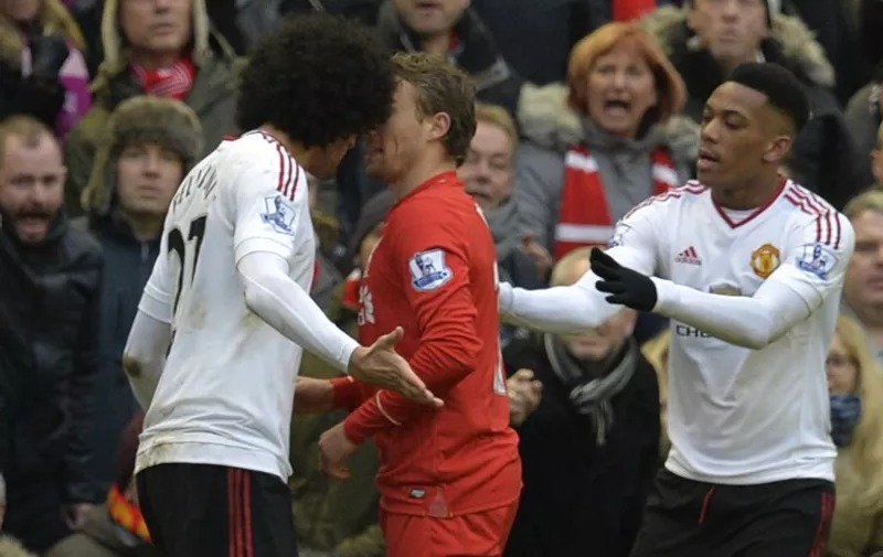 Manchester United's French striker Anthony Martial (R) intercedes between Manchester United's Belgian midfielder Marouane Fellaini (L) and Liverpool's Brazilian midfielder Lucas Leiva (C) as they exchange words after a challenge during the English Premier League football match between Liverpool and Manchester United at Anfield in Liverpool, northwest England, on January 17, 2016.  AFP PHOTO / PAUL ELLIS

RESTRICTED TO EDITORIAL USE. No use with unauthorized audio, video, data, fixture lists, club/league logos or 'live' services. Online in-match use limited to 75 images, no video emulation. No use in betting, games or single club/league/player publications. / AFP / PAUL ELLIS