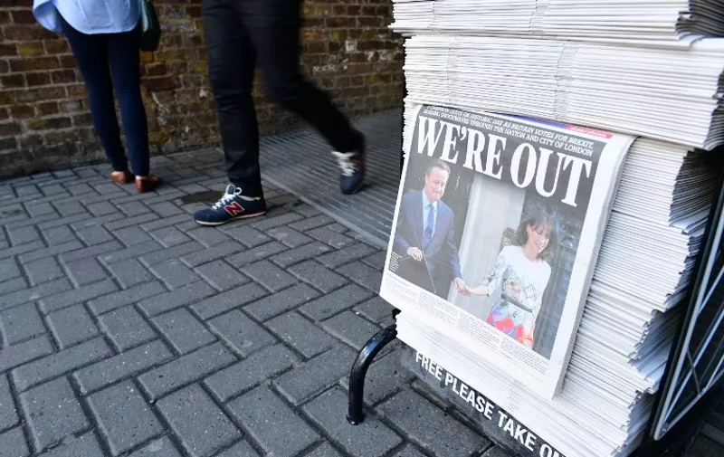 The front page of the London Evening Standard showing British Prime Minister David Cameron holding hands with his wife Samantha as they come out from 10 Downing Street to make an announcement following the results of the EU referendum are seen in London on June 24, 2016. 
Britain voted to break away from the European Union on June 24, toppling Prime Minister David Cameron and dealing a thunderous blow to the 60-year-old bloc that sent world markets plunging. / AFP PHOTO / LEON NEAL
