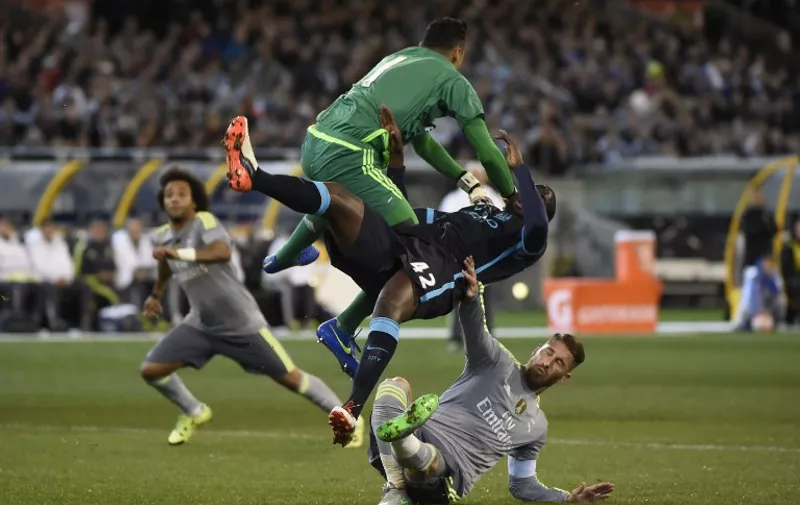 Goalkeeper Keilor Navas (top) of Real Madrid punches the ball away from Yaya Toure of Manchester City and team-mate Pep (bottom) during the International Champions Cup football match between English Premier League team Manchester City and Spanish side Real Madrid in Melbourne on July 24, 2015. AFP PHOTO / Mal FAIRCLOUGH -- IMAGE RESTRICTED TO EDITORIAL USE - STRICTLY NO COMMERCIAL USE