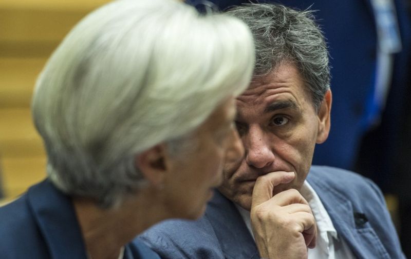 Greek Finance Minister Euclid Tsakalotos (R) speaks with Managing Director of the International Monetary Fund (IMF) Christine Lagarde during a meeting of the Eurogroup finance ministers in Brussel on July 12, 2015. The EU cancelled a full 28-nation summit today to decide Greece's fate in the single European currency, although a meeting of leaders from the 19 countries in the eurozone will go ahead as planned.  AFP PHOTO / JOHN MACDOUGALL