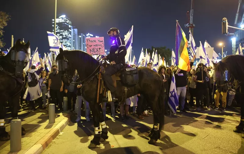 Mounted Israeli police stand guard as protesters attend a gathering in Tel Aviv on March 27, 2023, amid ongoing demonstrations and calls for a general strike against the hard-right government's controversial push to overhaul the justice system. (Photo by GIL COHEN-MAGEN / AFP)