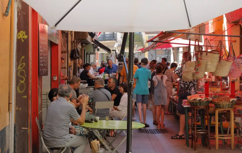 Food stalls and cafes on the Rue Paratilla, a short but busy street filled with food stalls, delicatessens, shops and cafes, in Perpignan, Pyrenees-Orientales, Catalogne du Nord, France. Picture by Manuel Cohen (Photo by Manuel Cohen / Manuel Cohen / Manuel Cohen via AFP)
