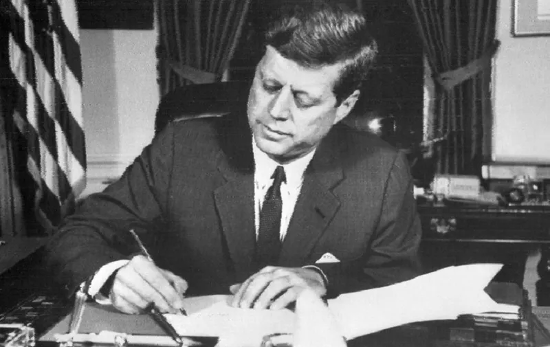 (FILES) This file photo taken on October 24, 1962 shows US President John Fitzgerald Kennedy signing the order of naval blockade of Cuba at the White House in Washington, DC, during the Cuban missiles crisis. 
The National Archives will release 2,800 records on October 26, 2017 about the assassination of president John F. Kennedy, but is delaying the publication of some "sensitive" files, administration officials said. President Donald Trump agreed to delay the release of some documents related to the November 22, 1963 assassination at the request of the CIA, FBI and other agencies, the officials said. / AFP PHOTO / AFP FILES / -