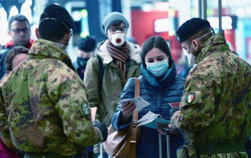 Soldier (L and R) wearing a respiratory mask control passengers arriving at the Milan Centrale railway station on March 9, 2020 as Italy is battling the world's second-most deadly virus outbreak after China and has imposed a virtual lockdown on the north of the country. (Photo by Miguel MEDINA / AFP)