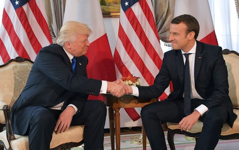 US President Donald Trump (L) and French President Emmanuel Macron (R) shake hands ahead of a working lunch, at the US ambassador's residence, on the sidelines of the NATO (North Atlantic Treaty Organization) summit, in Brussels, on May 25, 2017. / AFP PHOTO / Mandel NGAN