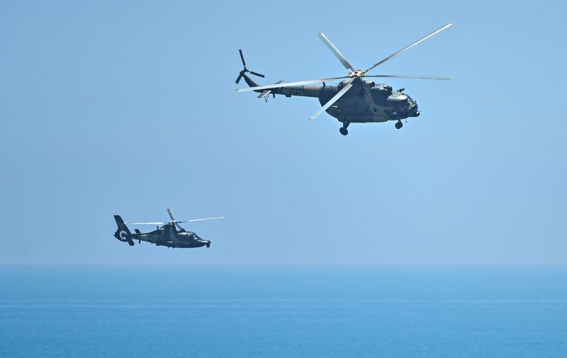 Chinese military helicopters fly past Pingtan island, one of mainland China's closest point from Taiwan, in Fujian province on August 4, 2022, ahead of massive military drills off Taiwan following US House Speaker Nancy Pelosi's visit to the self-ruled island. - China's largest-ever military exercises encircling Taiwan kicked off on August 4, in a show of force straddling vital international shipping lanes after a visit to the island by US House Speaker Nancy Pelosi. (Photo by Hector RETAMAL / AFP)