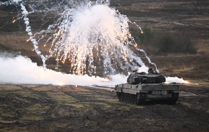 A Leopard 2 tank is seen in front of a wall of smoke and sparks at the training ground in Augustdorf, western Germany on February 1, 2023, during a visit of the German Defence Minister of the Bundeswehr Tank Battalion 203, to learn about the performance of the Leopard 2 main battle tank. (Photo by INA FASSBENDER / AFP)