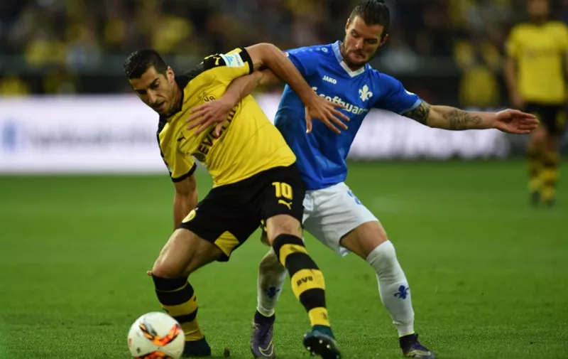 Darmstadt's midfielder Marcel Heller and Dortmund's Armenian midfielder Henrikh Mkhitaryan (L) vie for the ball during the German first division Bundesliga football match Borussia Dortmund v SV Darmstadt 98, in Dortmund, western Germany, on September 27, 2015. AFP PHOTO / PATRIK STOLLARZ

RESTRICTIONS: DURING MATCH TIME: DFL RULES TO LIMIT THE ONLINE USAGE TO 15 PICTURES PER MATCH AND FORBID IMAGE SEQUENCES TO SIMULATE VIDEO. 
== RESTRICTED TO EDITORIAL USE ==
FOR FURTHER QUERIES PLEASE CONTACT DFL DIRECTLY AT + 49 69 650050.