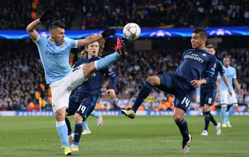 Manchester City's Argentinian striker Sergio Aguero (L) battles with Real Madrid's Croatian midfielder Luka Modric (C) and Real Madrid's Brazilian midfielder Casemiro (R) during the UEFA Champions League semi-final first leg football match between Manchester City and Real Madrid at the Etihad Stadium in Manchester, northwest England, on April 26, 2016. / AFP PHOTO / OLI SCARFF