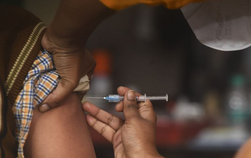 A health official (L) prepares to administer a vaccine during a dry run or a mock drill for Covid-19 coronavirus vaccine delivery at a primary health centre  in Kolkata on January 2, 2021. (Photo by Dibyangshu SARKAR / AFP)