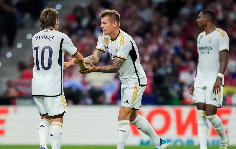Real Madrid's Toni Kroos, center, celebrates with teammate Luka Modric after scoring his side's first goal during the Spanish La Liga soccer match between Atletico Madrid and Real Madrid at Metropolitan stadium in Madrid, Sunday, Sept. 24, 2023. (AP Photo/Manu Fernandez)
