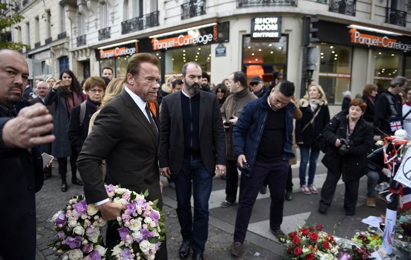 Former governor of California and film star Arnold Schwarzenegger arrives to pay his respects at a memorial outside the Bataclan concert hall on December 5, 2015 in Paris. / AFP / MARTIN BUREAU