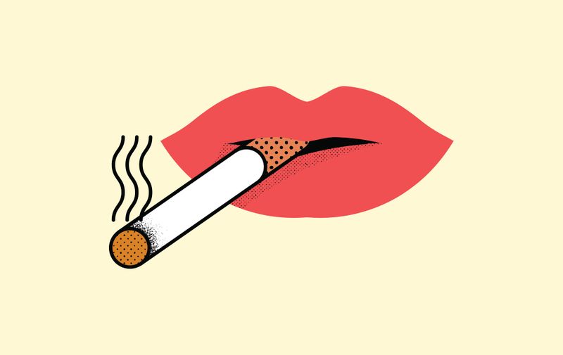 Female lips holding cigarette in the mouth