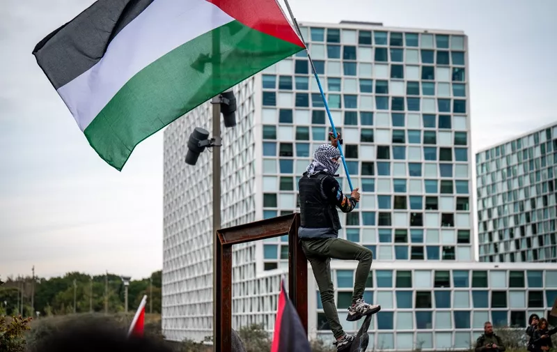 A protestor wearing a Palestinian Keffiyeh scarf takes part in a demonstration in solidarity with Palestinians in front of the International Criminal Court in the Hague on October 18, 2023, a day after the death of hundreds of people in a strike on a Gaza hospital. (Photo by Josh Walet / ANP / AFP) / Netherlands OUT