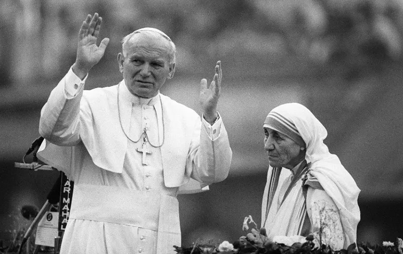 Photo dated 03 February 1986 shows Mother Teresa and Pope John Paul II waving to well-wishers in Calcutta. The pontiff was on a 10 days state visit to India. / AFP / JEAN-CLAUDE DELMAS