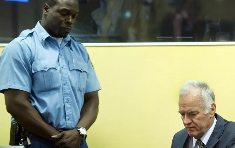 Former Bosnian Serb army chief Ratko Mladic (R) sits on May 16, 2012 at the International Criminal Tribunal for the former Yugoslavia (ICTY) in The Hague before the opening of his war crimes trial. Mladic faces 11 counts including genocide, war crimes, and crimes against humanity for his role in the Bosnian war, in particular the 1995 Srebrenica massacre.  AFP PHOTO / POOL / TOUSSAINT KLUITERS        - netherlands out -