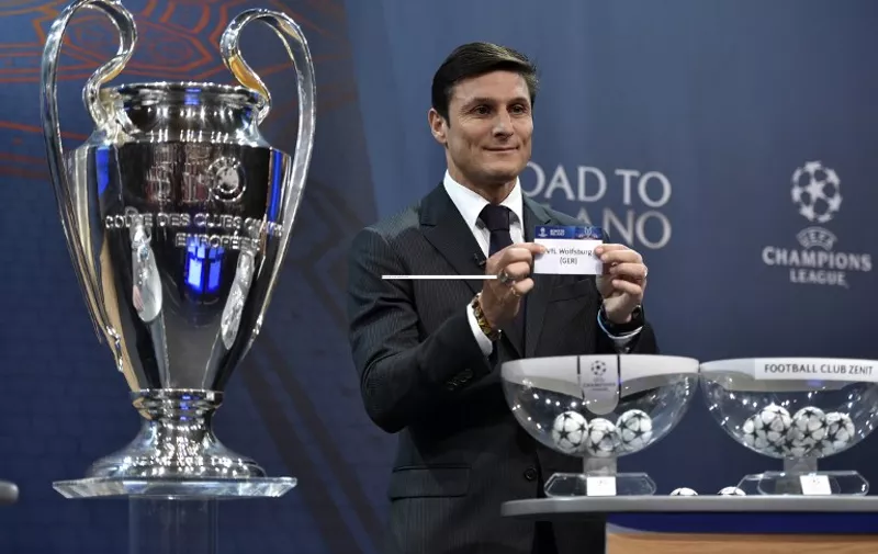 UEFA Champions League final ambassador  Javier Zanetti shows the name of Wolfsburg during the draw for the UEFA Champions league round of sixteen, on December 14, 2015 at the European football organization's headquarters in Nyon.  AFP PHOTO / FABRICE COFFRINI / AFP / FABRICE COFFRINI