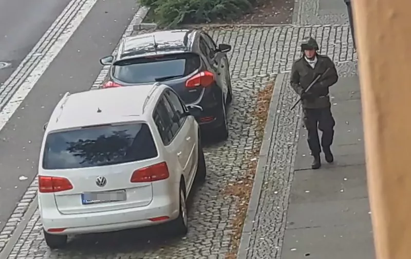 In this screenshot taken from a video by ATV-Studio Halle, a man walks with a gun in the streets of Halle an der Saale, eastern Germany, on October 9, 2019. - At least two people were shot dead on a street in Halle, police said, with witnesses saying that a synagogue was among the gunmen's targets as Jews marked the holy day of Yom Kippur. One suspect was captured but with a manhunt ongoing for other perpetrators, security has been tightened in synagogues in other eastern German cities while Halle itself was in lockdown. (Photo by Andreas Splett / ATV-Studio Halle / AFP) / RESTRICTED TO EDITORIAL USE