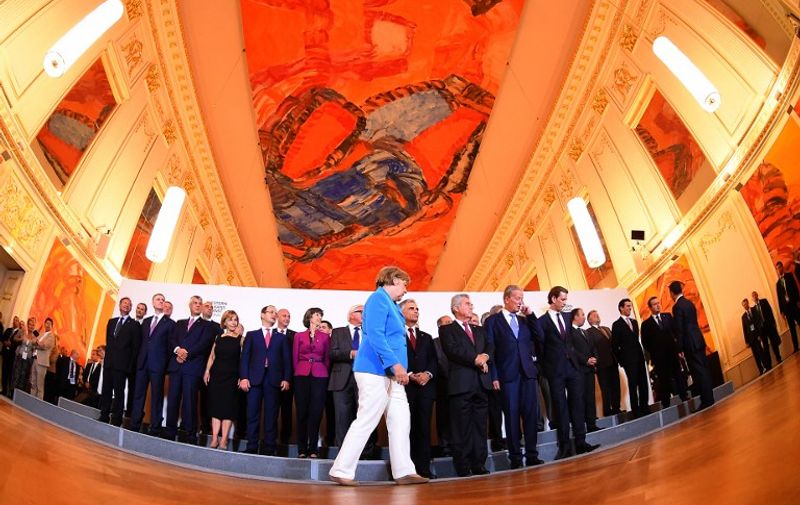 German Chancellor Angela Merkel walks in front of the participanting leaders of Western Balkan countries and EU during the family photo during the Western Balkans Summit at the Hofburg palace in Vienna, Austria on August 27, 2015. Serbia and Macedonia's foreign ministers called for EU action on Europe's migrant crisis at a summit of leaders from the western Balkans, attended by German Chancellor Angela Merkel. AFP PHOTO / JOE KLAMAR
