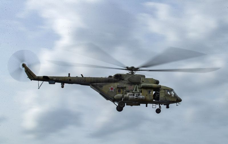 A Russian Mil Mi-8 military helicopter flies over a joint Russian and Turkish convoy (not pictured) as it patrolls in oil fields near the town of al-Qahtaniyah, in Syria's northeastern Hasakeh province close to the Turkish border, on February 4, 2021. (Photo by Delil SOULEIMAN / AFP)