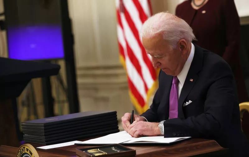 WASHINGTON, DC - JANUARY 21: U.S. President Joe Biden signs an executive order during an event in the State Dining Room of the White House January 21, 2021 in Washington, DC. President Biden delivered remarks on his administrations COVID-19 response, and signed executive orders and other presidential actions.   Alex Wong/Getty Images/AFP