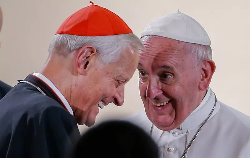 Pope Francis (R) laughs with Cardinal Donald Wuerl (L) after arriving to visit St. Patrick in the City Catholic church in Washington DC, September 24, 2015. St. Patrick is the oldest Catholic church in Washington, founded in 1794. Pope Francis is on a five-day trip to the USA, which includes stops in Washington DC, New York and Philadelphia, after a three-day stay in Cuba. AFP PHOTO/POOL/ERIK S. LESSER (Photo by ERIK S. LESSER / POOL / AFP)