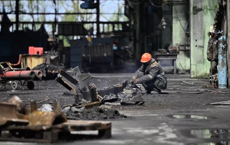 Workers clean debris in a turbine hall full of scorched equipments at a power plant of energy provider DTEK, destroyed after an attack, in an undisclosed location in Ukraine on April 19, 2024, amid the Russian invasion of Ukraine. Russia was able to destroy a key power plant serving Kyiv because Ukraine ran out of defensive missiles, President Volodymyr Zelensky said on April 16, 2024. For three-and-a-half weeks, Russia has launched near continuous strikes on Ukraine's power grid, leaving over a million people without electricity. (Photo by Genya SAVILOV / AFP)