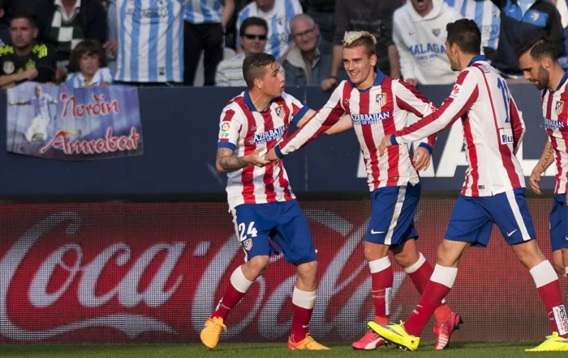 Atletico Madrid&#8217;s French forward Antoine Griezmann (2ndL) celebrates after scoring with his teammates during the Spanish league football match Malaga CF vs Club Atletico de Madrid at La Rosaleda stadium in Malaga on April 11, 2015. The game ended with a draw 2-2. AFP PHOTO/ JORGE GUERRERO