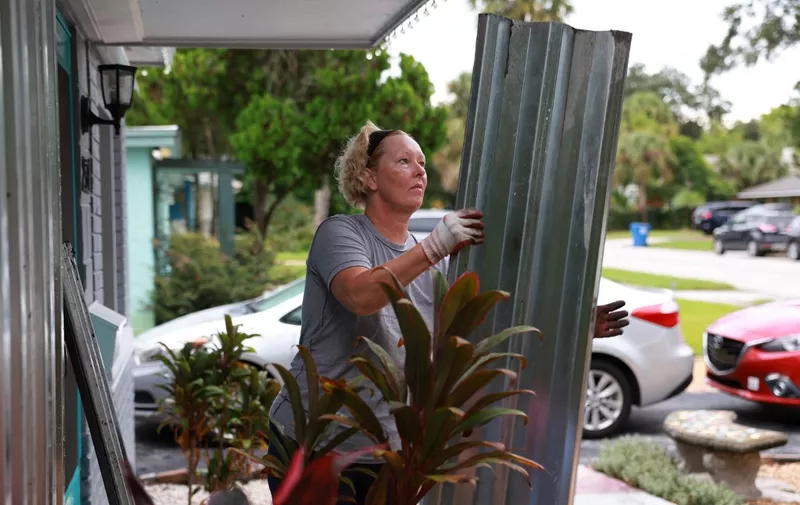 ST. PETERSBURG, FLORIDA - SEPTEMBER 27: Rebecca Hale places shutters on her home as she prepares for the possible arrival of Hurricane Ian on September 27, 2022 in St Petersburg, Florida. Ian is expected in the Tampa Bay area Wednesday night into early Thursday morning.   Joe Raedle/Getty Images/AFP (Photo by JOE RAEDLE / GETTY IMAGES NORTH AMERICA / Getty Images via AFP)