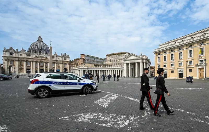 Italian Police patrols on Piazza Pope Pius XII in Rome at the limit with The Vatican's St. Peter's Square and its Basilica (Rear) on April 13, 2020, during the lockdown aimed at curbing the spread of the COVID-19 infection, caused by the novel coronavirus. (Photo by Vincenzo PINTO / AFP)