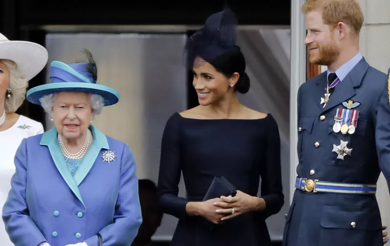 (FILES) In this file photo taken on July 10, 2018 (L-R) Britain's Queen Elizabeth II, Meghan, Duchess of Sussex, Britain's Prince Harry, Duke of Sussex stand on the balcony of Buckingham Palace in London to watch a military fly-past to mark the centenary of the Royal Air Force (RAF). - Britain's Queen Elizabeth II on January 13, 2020, said Prince Harry and his wife Meghan would be allowed to split their time between Britain and Canada while their future is finalised. The couple said last week they wanted to step back from the royal frontline, catching the family off guard and forcing the monarch to convene crisis talks about the pair's future roles. (Photo by Tolga AKMEN / AFP)