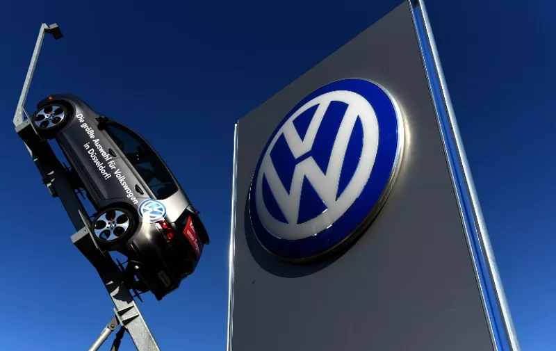 (FILES) This picture taken on September 28, 2015 shows a model and logo of German car maker Volkswagen (VW) are seen at the entrance to a VW branch in Duesseldorf, western Germany.  Michael Horn, president and chief executive of Volkswagen Group of America, apologized to Congress and said the company takes "full responsibility" for the emissions cheating scandal, according to testimony released on October 8, 2015.  AFP PHOTO / PATRIK STOLLARZ.