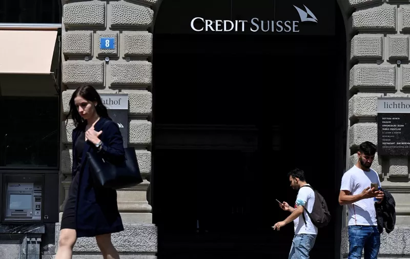 People pass by the headquarters of Swiss bank Credit Suisse in Zurich on August 9, 2021. (Photo by SEBASTIEN BOZON / AFP)